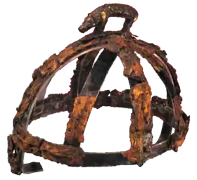 Une structure de métal corrodé en forme de dôme, surmontée d'un petit sanglier.