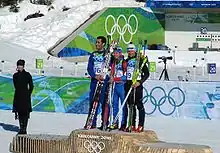 podium de la mass start des jeux de Vancouver. Les trois biathlètes sont ensemble sur la plus haute marche du podium.