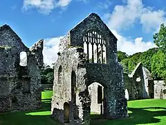 Photo de plusieurs bâtiments en ruine entourés de pelouse