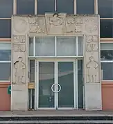 Le portique sculpté de l'école primaire, signé Yvonne Gisclard-Cau et Paul Manaut.