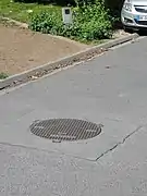 Tête de puits matérialisée no&nbsp;1 bis, la stèle est en arrière-plan.