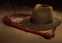 Un fouet entouré sur lui-même et un chapeau marron.