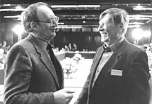 Photo noir et blanc de deux hommes souriants en train de discuter