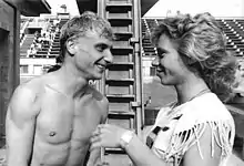 Regard intense entre le plongeur souriant, torsu nu, et la femme sur la droite de la photo.