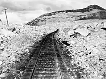 Chemin de fer entouré de débris rocheux.