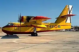 vue de profil d'un canadair jaune et rouge au sol.