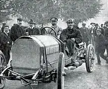 Photo d'un conducteur et de son mécanicien embarqué, prenant la pause au volant de leur véhicule.