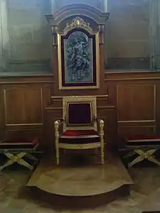 Cathèdre (fin du XVIIIe&nbsp;siècle) en bois doré et les deux tabourets assortis, avec derrière un panneau représentant le Christ revenant dans la gloire sur le cadre du lambris mouluré chêne et doré et deux consoles sur les côtés du panneau et à agrafe à coquille et rubans en haut.