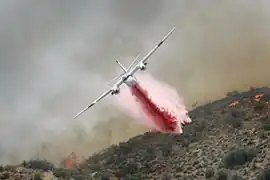 Un Tracker S-2FT du CAL FIRE (en) larguant du retardant.