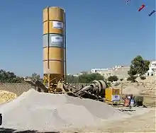 Centrale à béton. Procédé hors site de construction en usage après 1970, malaxeur et transporteur à bande.