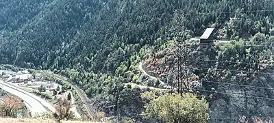 Photographie d'une usine électrique et gare de départ du téléphérique, dominant plus ou moins une vaste forêt.