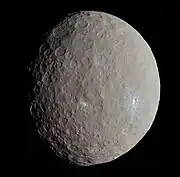 Sphère grise cratérisée présentant quelques zones blanches.