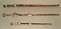 Deux épées chinoises (haut) de la dynastie Sui. Bas : sabre japonais avec fourreau, période Kofun, VIe&nbsp;siècle (Met Museum).