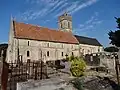 L'église vue du sud, à gauche la nef au toit de tuiles, le haut du clocher, le chœur à droite.