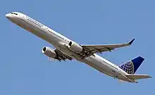 Vue du dessous d'un avion de ligne à réacteurs qui s'élève dans les airs.