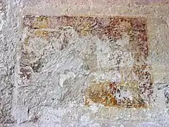 Photographie en couleurs d'une peinture à demi-effacée sur un mur.