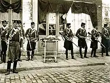 photographie noir et blanc : des hommes en armes dans une rue