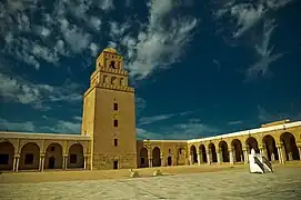 Vue de la cour et du minaret à trois étages dégressifs superposés.