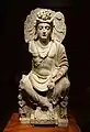 Maitreya, avec un couple de dévots Kushan à ses pieds. IIe&nbsp;siècle, Mardan, Gandhara.