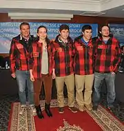 5&nbsp;personnes dont une femme en veste de ski à carreaux rouges et noirs, pantalon de ville