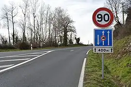 Panneau C24a sur une route à deux voies dans le sens de circulation, une dans le sens opposé