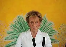 Femme tenant un discours avec micros.