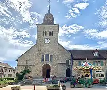 L’église Saint-Nithier avec un carrousel dans une ambiance estivale et légère.