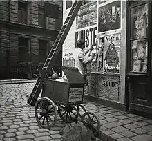 Colleur d’affiche dans les rues de Vienne en Autriche, photographié par Emil Mayer au début du XXe siècle.