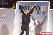 Un homme lève les bras sur un podium