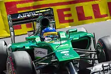 Photographie d'une monoplace de Formule vert foncé, en gros plan, de face.