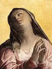 Peinture d'une femme représentant la Vierge, les yeux au ciel, mains jointes en prière.