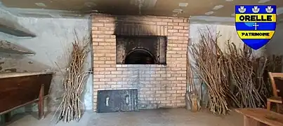 Photographie du four à pain de Bonvillard, en briques, vu depuis l'entrée est avec les fagots de chaque côté.