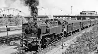 Un train de banlieue tracté par la 141 TD 128 quitte la gare de Achères en direction de Mantes en 1958.