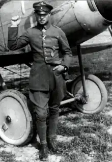 Photo noir et blanc d'un homme adossé à un avion.