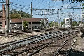 Vue des voies au nord de la gare, et, à l'arrière-plan, derrière le poste d'aiguillage, la voie en provenance de Firminy de la ligne de Firminy à Saint-Rambert-d'Albon.