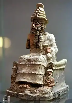 Statuette en terre cuite du dieu Enki/Ea sur un trône, une coupe à la main. Période paléo-babylonienne, début du IIe millénaire av. J.-C. Musée national d'Irak.