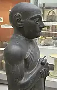 Statue V, détail : haut du corps avec épaule et bras visibles, tête recollée. British Museum.