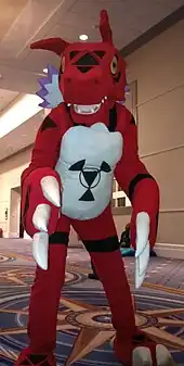 Photo d'une personne déguisée en une sorte de dinosaure rouge et blanc.