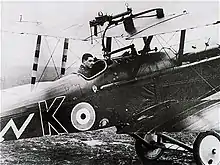 Gwilym Hugh Lewis aux commandes de son appareil, de 3/4 dos.