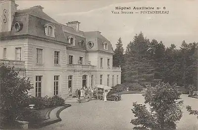 Une ambulance et du personnel stationnés sur le perron de la villa dans la cour d’Honneur durant la Première Guerre mondiale.
