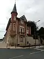 Élégant Hôtel en briques rouges avec sa tourelle derrière l'église St Jean-St Louis.