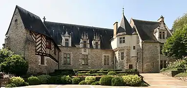 Photographie d'un manoir : des colombages à gauche ; une petite tour à gauche.