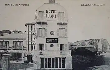 L'hôtel Blanquet à Étretat vers 1890 avec l'enseigne d'Eugène Lepoittevin sur sa façade. Carte postale (début du XXe&nbsp;siècle).