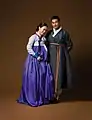 Hanbok (costume traditionnel): Une femme portant un jeogori (veste) serré et une chima&nbsp;(en) (jupe) / Un homme en durumagi (manteau traditionnel)