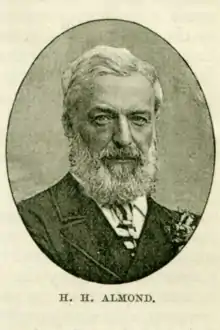 Photographie en noir et blanc en médaillon représentant un homme barbu âgé en buste.