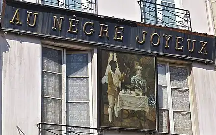 Au no&nbsp;14, l'enseigne Au Nègre joyeux (déposée).