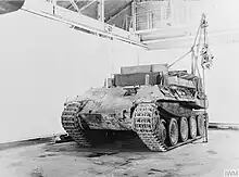 Photographie d’époque d’un Bergepanther vu de trois-quart avant dans un hangar.