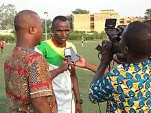 Un sportif interrogé sur un terrain de football.