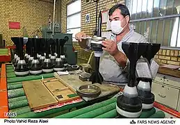 Un ouvrier iranien assemblant le sabot d'un obus-flèche de 125&nbsp;mm.