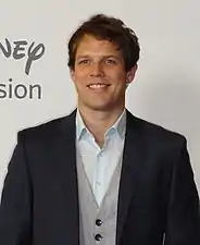 Jake Lacy interprète Robert Berchtold.